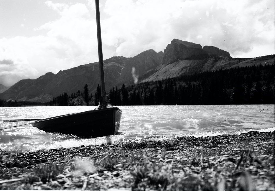 A low angle shot showing the sailboat  pulled up on Canmore Beach with Yamnuska in the background.